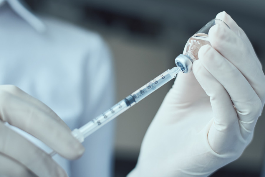 Cropped hands doctor holding syringe vial (1)